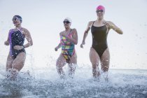 Nadadoras activas corriendo en el océano al aire libre - foto de stock