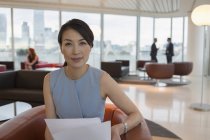 Porträt selbstbewusste Geschäftsfrau überprüft Papierkram in Büro-Lounge — Stockfoto