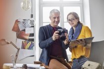 Photographers using digital tablet and digital camera in office — Stock Photo
