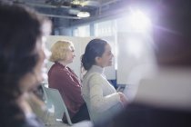 Smiling businesswomen listening in conference audience — Stock Photo
