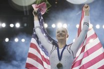 Усміхнене жіночий гімнастка святкування перемоги тримає американський прапор — стокове фото