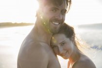 Портрет молодой пары, обнимающейся на пляже — стоковое фото