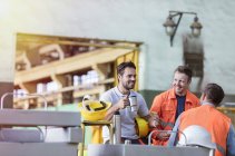 Lavoratori siderurgici sorridenti che godono di pausa caffè in fabbrica — Foto stock