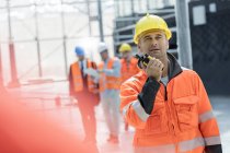 Male foreman using walkie-talkie at construction site — Stock Photo