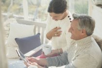 Ältere Paare trinken Kaffee und verwenden digitale Tablette auf der Veranda — Stockfoto