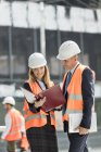 Architects reviewing paperwork at construction site — Stock Photo