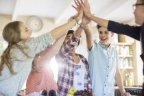 Group of teenagers doing high five in living room — Stock Photo