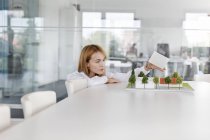 Архитектор-женщина строит модель в конференц-зале — стоковое фото