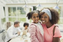 Portrait smiling mother and daughter hugging in kitchen — Stock Photo