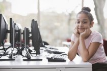 Retrato chica confiada estudiante investigando en la computadora en la biblioteca - foto de stock