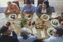 Overhead view friends talking and dining at restaurant table — Stock Photo