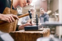 Jeweler using hammer in workshop — Stock Photo