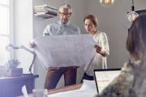 Architects reviewing blueprints in office — Stock Photo
