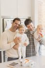 Ritratto maschio gay genitori holding bambino figli in cucina — Foto stock