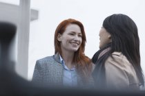 Усміхнені бізнес-леді спілкуються на відкритому повітрі разом — стокове фото