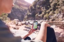 Junge Frau betrachtet digitale Landkarte auf Smartphone am Sonnenstrom — Stockfoto