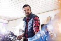 Retrato confiante masculino motocicleta mecânica trabalhando em oficina — Fotografia de Stock