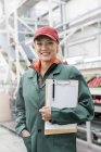 Portrait smiling worker with clipboard in food processing plant — Stock Photo