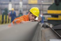 Lavoratore siderurgico che esamina l'acciaio in fabbrica — Foto stock