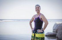Sonriente Nadadora femenina con toalla en las caderas - foto de stock