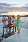 Jovens amigos adultos churrasco, sair e beber no barco de verão ao pôr-do-sol — Fotografia de Stock