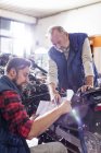 Мужская мотоциклетная механика рассматривает планы в мастерской — стоковое фото