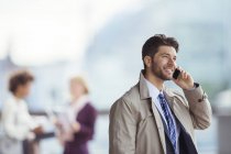 Businessman talking on cell phone outdoors — Stock Photo