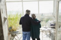 Liebevolles Senioren-Paar genießt Blick auf den Strand auf der Veranda — Stockfoto