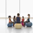 Mulheres em bolas de fitness em círculo em estúdio de ginástica de classe de exercício — Fotografia de Stock