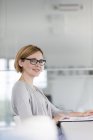 Портрет уверенной деловой женщины за ноутбуком в офисе — стоковое фото