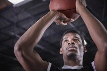 Enfocado joven jugador de baloncesto masculino tiro libre - foto de stock
