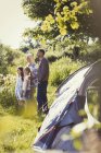 Position de famille à la tente ensoleillée du camping — Photo de stock