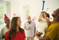 Familia multiétnica celebrando con favores de fiesta - foto de stock