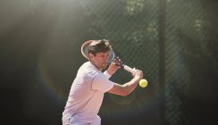 Jovem jogando tênis, balançando raquete de tênis — Fotografia de Stock