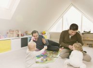 Masculino gay pais jogar com bebê filhos no playroom — Fotografia de Stock