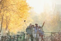 Verspielte junge Freunde machen Selfie mit Selfie-Stick auf urbaner Herbstbrücke in Amsterdam — Stockfoto
