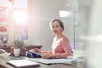 Портрет впевненої бізнес-леді, використовуючи цифровий планшет за столом в офісі — стокове фото
