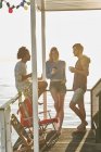 Giovani amici adulti appendere fuori sulla soleggiata casa galleggiante estiva — Foto stock