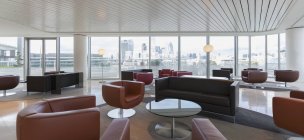 Muebles de cuero en salón de oficina urbano de gran altura - foto de stock