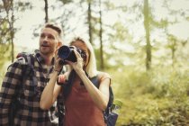 Couple randonnée et photographie bois avec appareil photo reflex numérique — Photo de stock