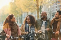 Amici in bicicletta sulla strada urbana autunno — Foto stock
