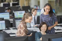 Предпринимательницы, использующие компьютер в офисе открытого плана — стоковое фото