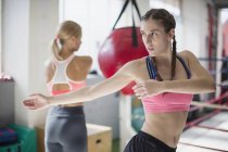 Fokussierte junge Boxerin dehnt sich, dreht sich im Fitnessstudio — Stockfoto