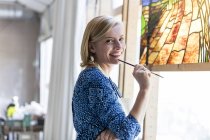Retrato sonriente artista trabajando en vidrieras - foto de stock