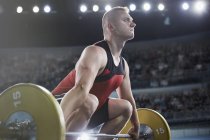 Focused male weightlifter lifting barbell — Stock Photo