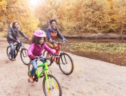 Young family bike riding along pond in woods — Stock Photo