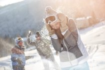Playful skier friends enjoying snowball fight in snowy field — Stock Photo