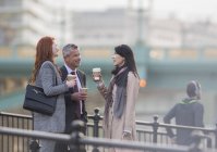 Деловые люди пьют кофе и разговаривают на городской рампе — стоковое фото