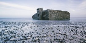 Ruines dans l'océan à marée basse et rochers sur la plage, Vigsoe, Danemark — Photo de stock