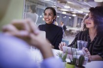 Lächelnde Geschäftsfrauen hören im Konferenzraum zu — Stockfoto